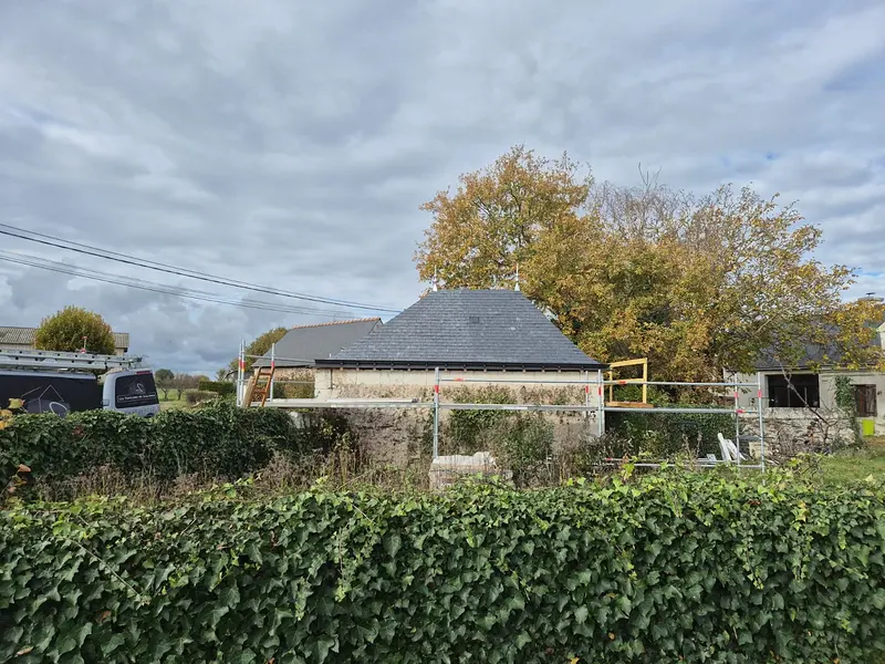 Dépendance en pierre couverte d'une toiture en ardoise neuve à quatre pans