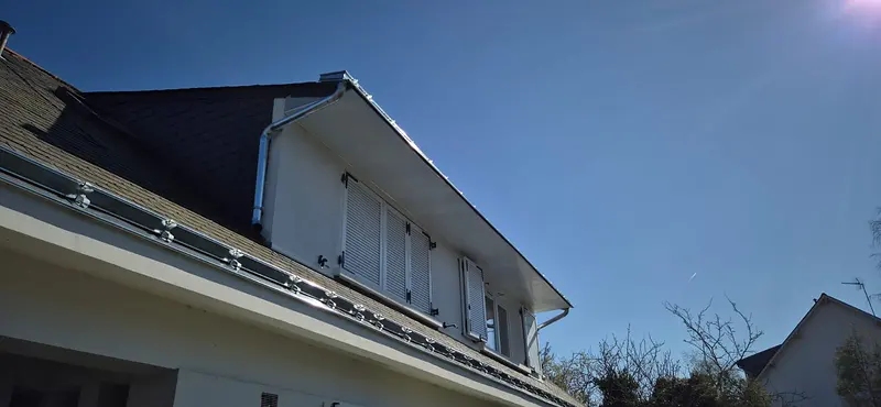 Gouttière et descente en zinc posées sur une maison à lucarnes