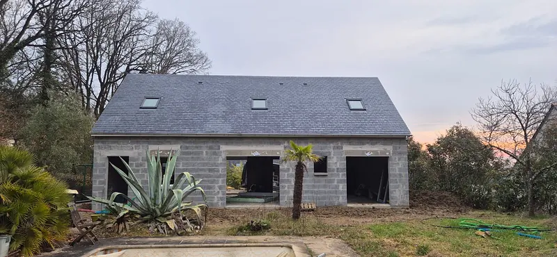 Maison neuve couverte en ardoise avec trois fenêtres de toit