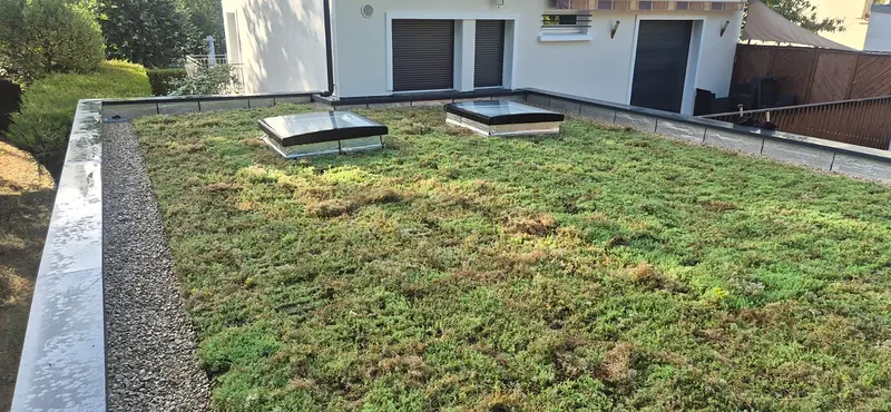 Toiture terrasse végétalisée avec lanterneaux et couvertine en rive