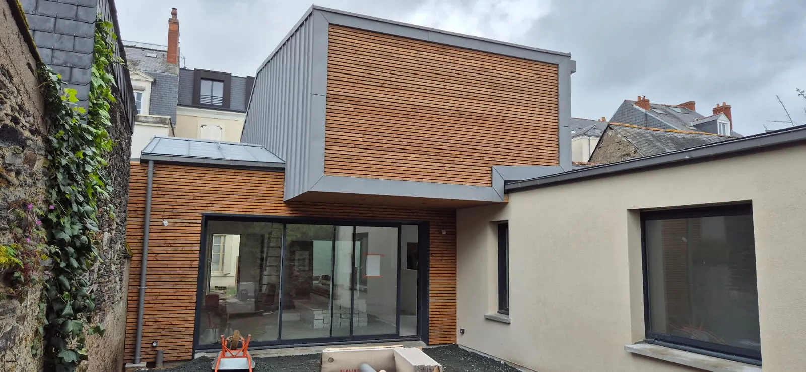 Extension contemporaine habillée de zinc à joint debout et de bardage bois